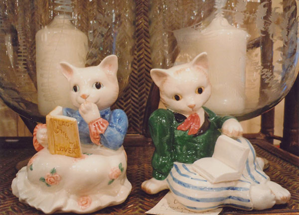 Two statuettes of cats holding books